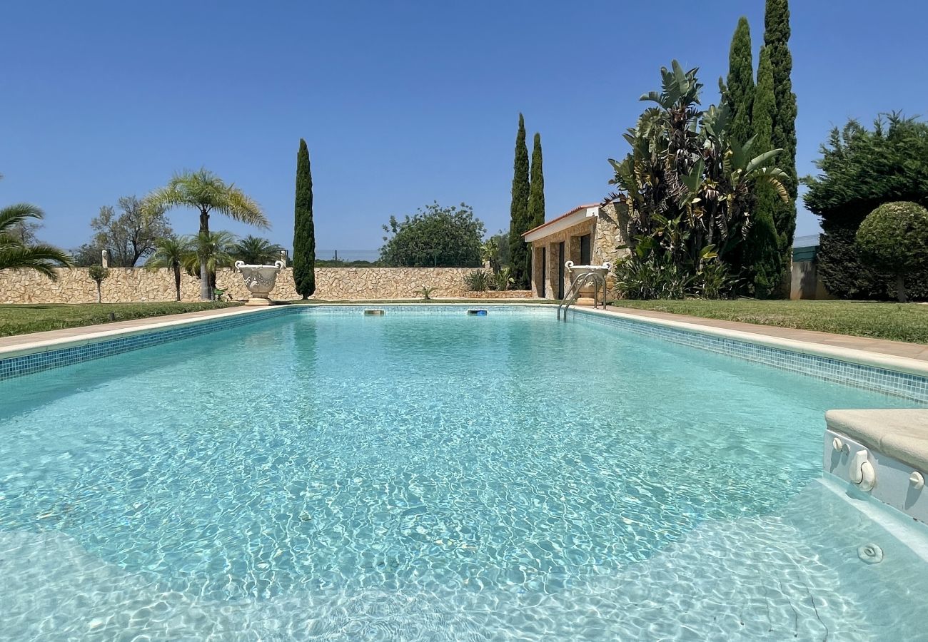 Piscina privada rodeada por amplo espaço exterior e zona ajardinada em Quarteira