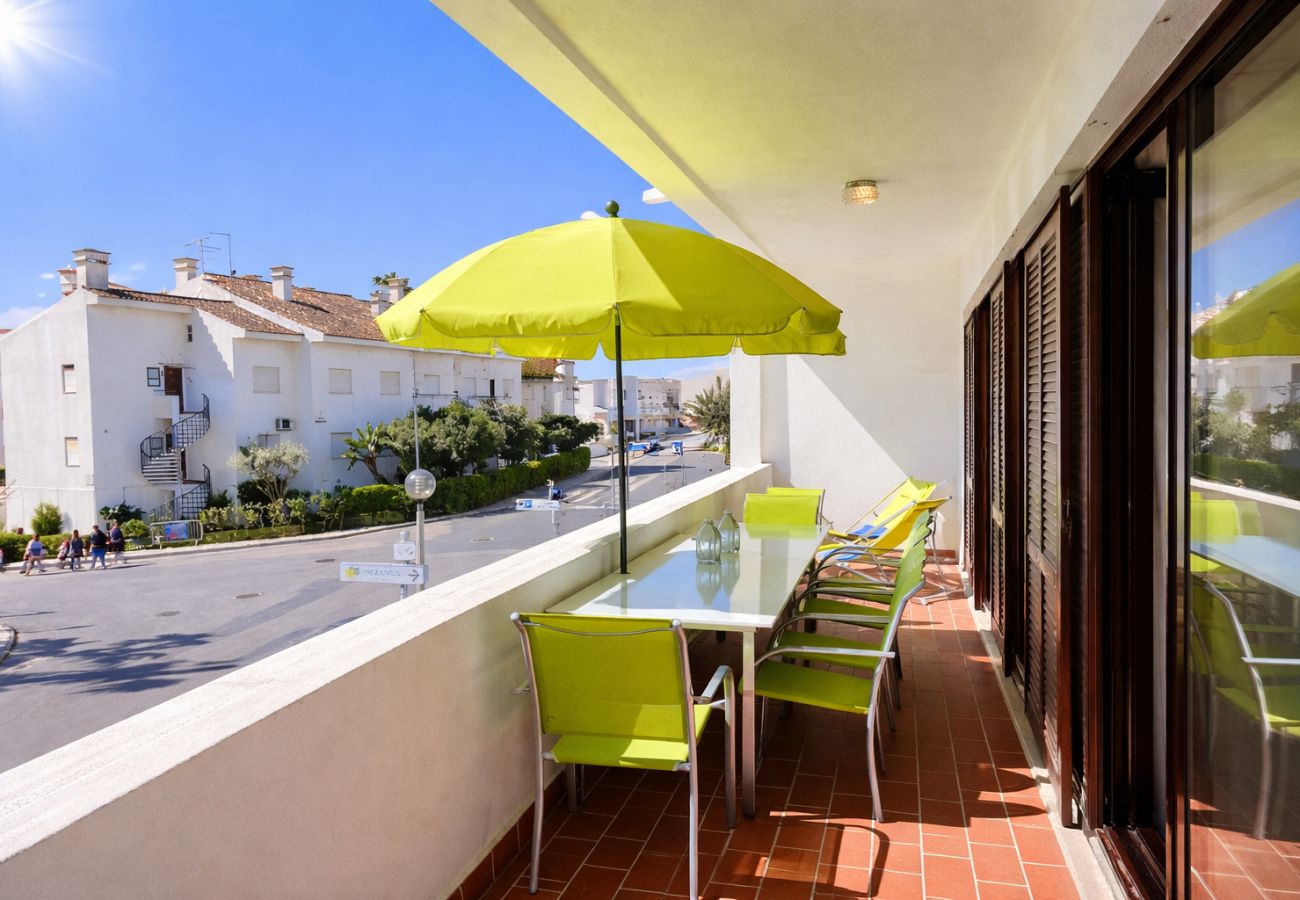 Furnished apartment terrace in Olhos d’Água with outdoor dining area and street view, close to the beach