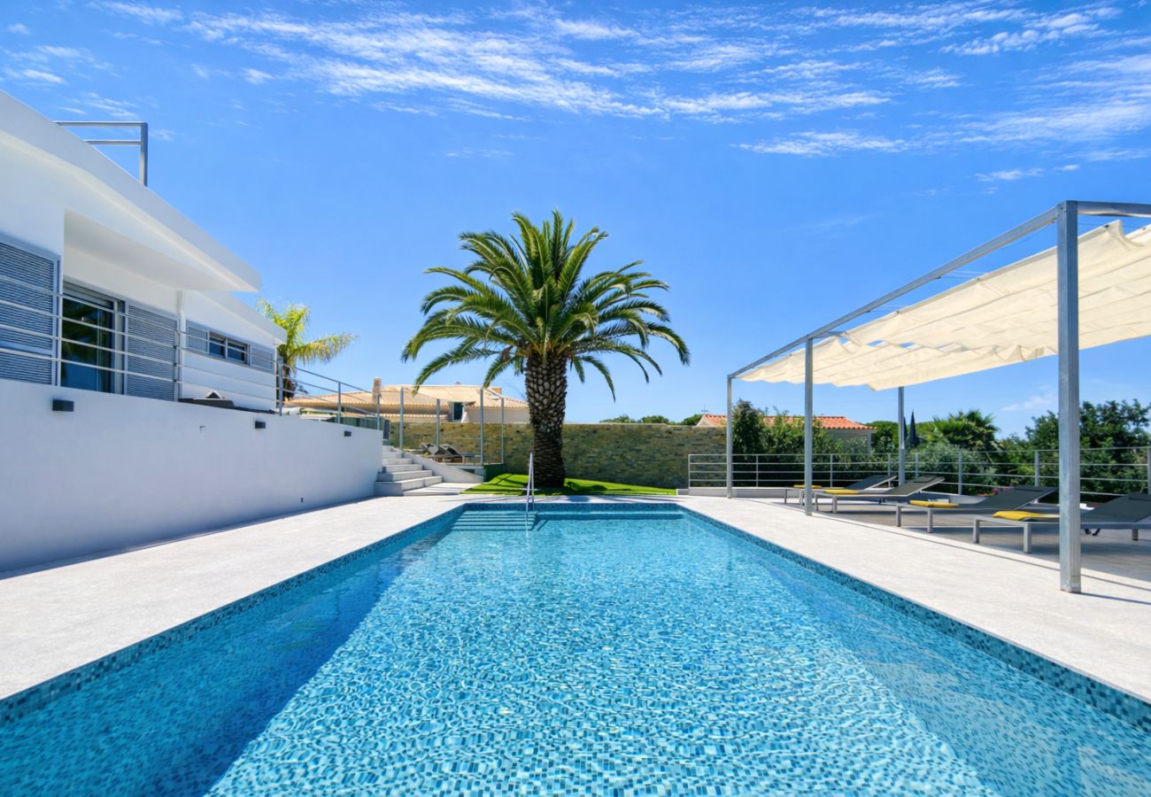 Piscine privée d'une maison moderne à Quarteira, avec solarium et architecture contemporaine